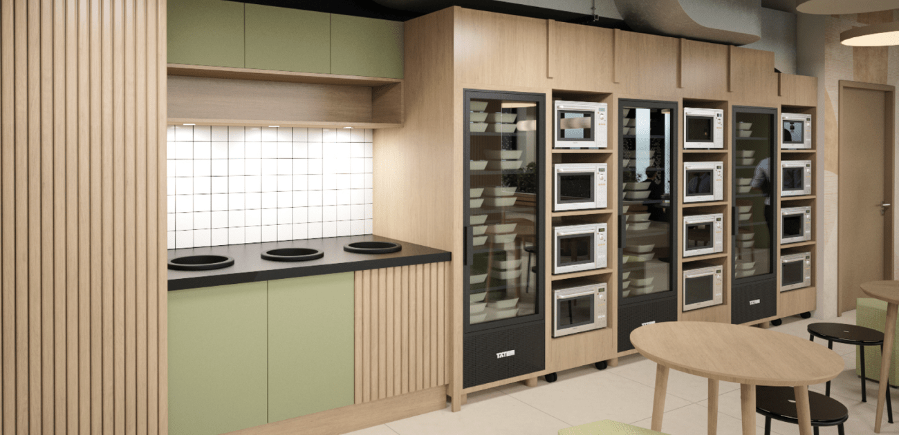 Frigo connecté ouvert dans un espace de bureau lumineux, deux collaborateurs en train de se servir